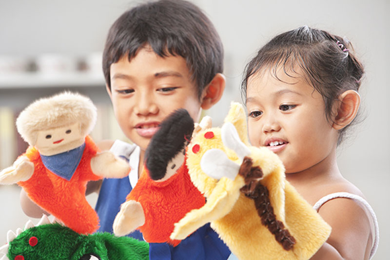 Indoor activities for kids. Two preschoolers playing with puppets.