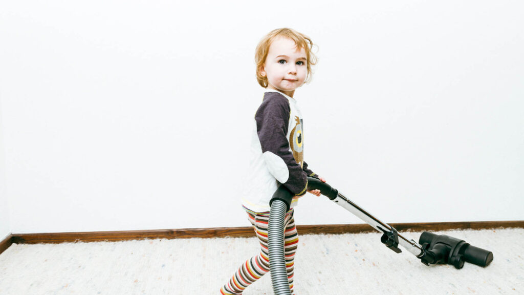 Child vacuuming carpeted floor