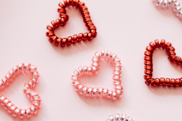 flat lay of four coil pink and red hair ties shaped like hearts