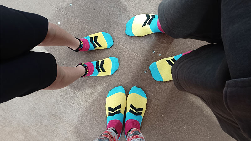 Three pairs of feet wearing Bounce Inc trampoline park's supplied socks